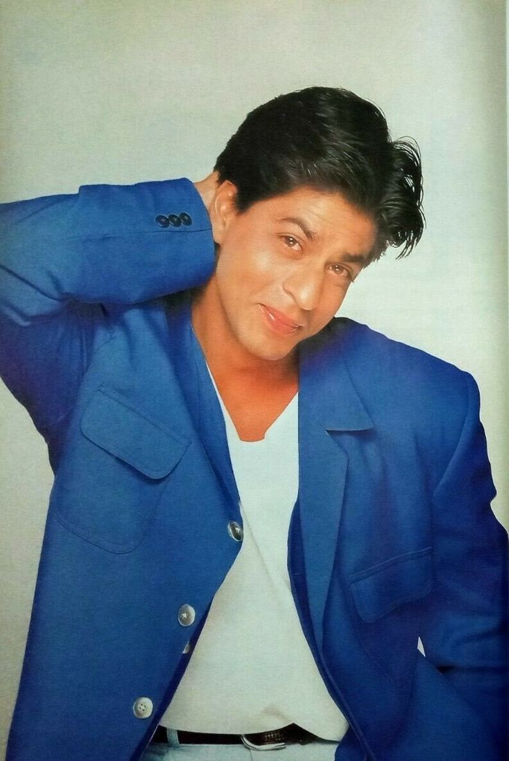 a man in a blue blazer is posing for a photo with his hand on his head