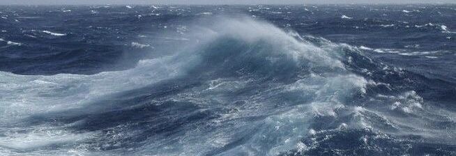 a large wave in the middle of the ocean