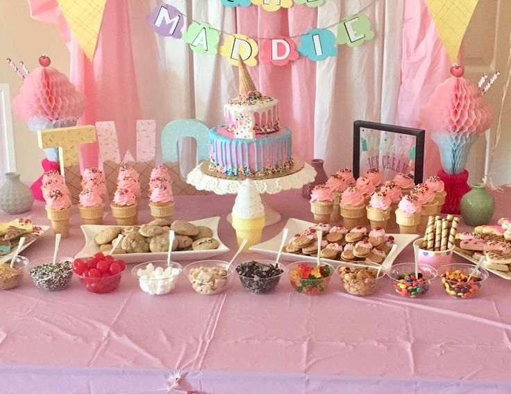 a pink table topped with lots of desserts and cupcakes on top of it