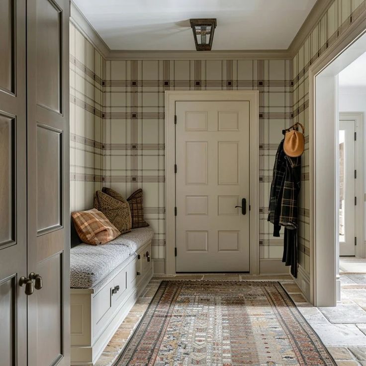 a hallway with a bench, coat rack and two doors