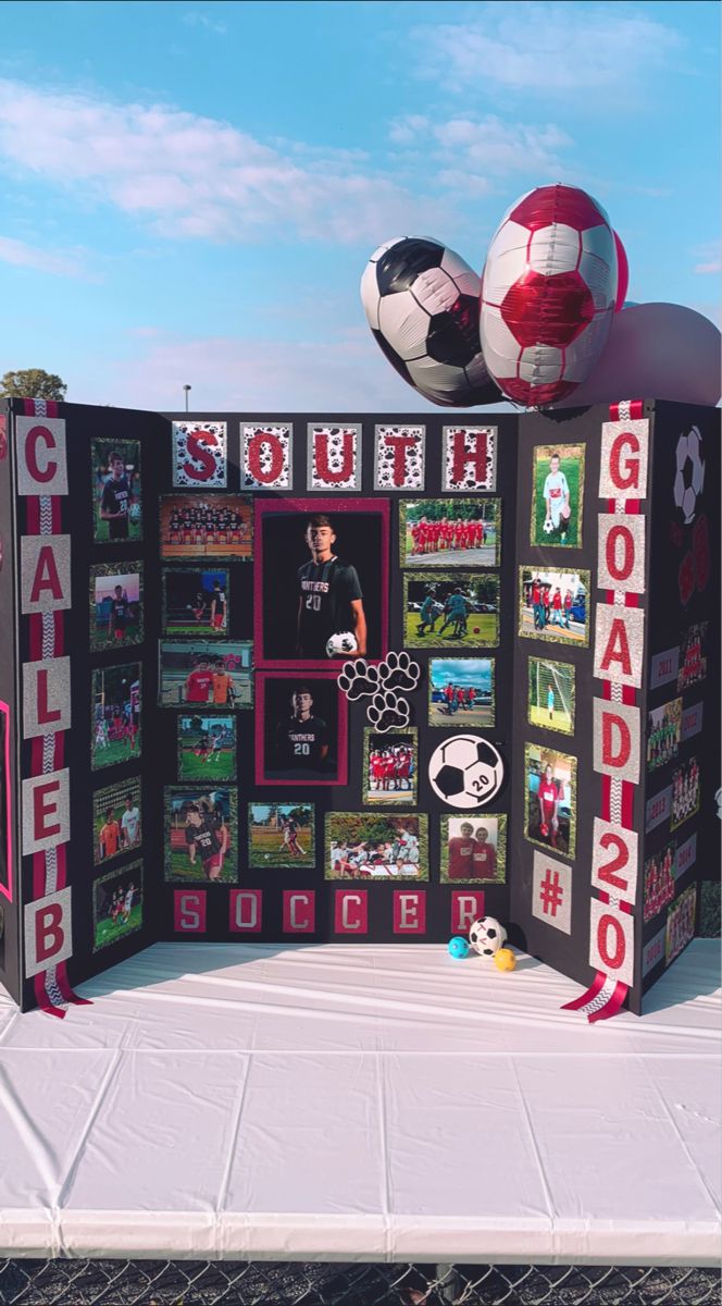 a soccer themed display on the side of a fence with balls and pictures all over it