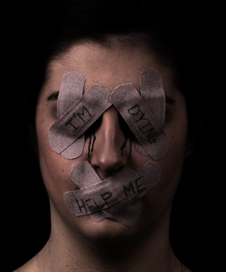 a woman with tape taped to her face and the words help me written on it