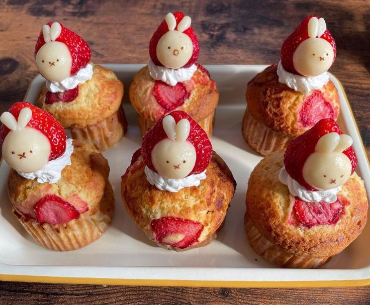 there are many small cupcakes with strawberries in the shape of bunnies