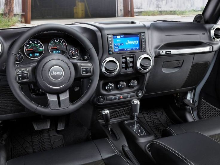 the interior of a jeep with black leather seats and dash board, steering wheel, dashboard