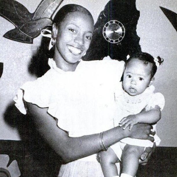 a black and white photo of a woman holding a baby