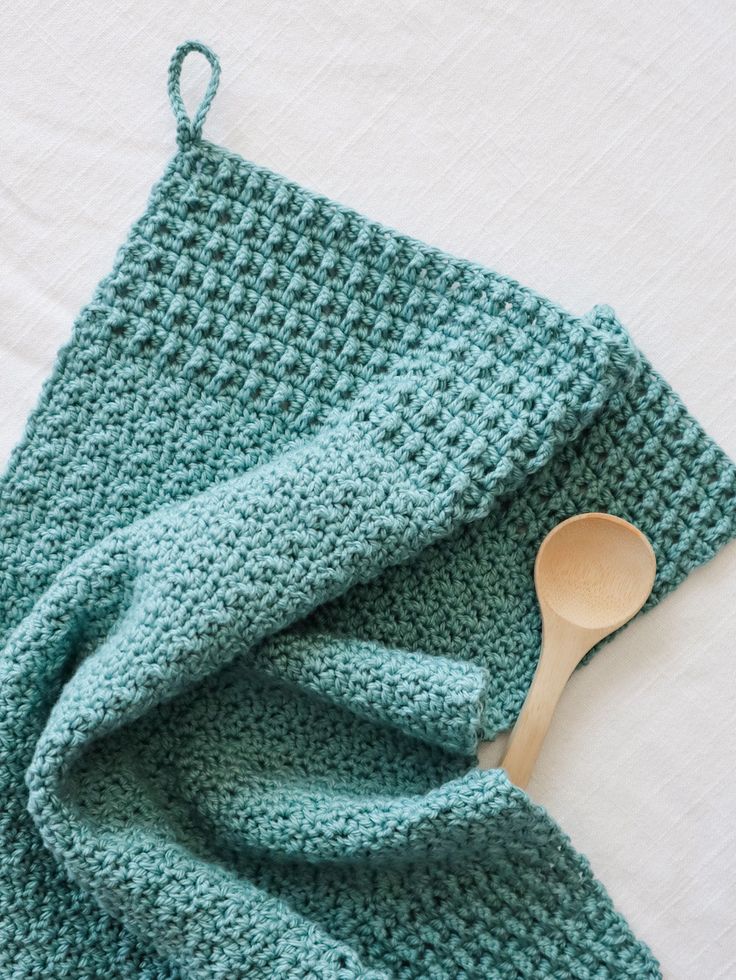 a crocheted dish cloth with a wooden spoon on it and the words, bosk tea towel i crochet pattern