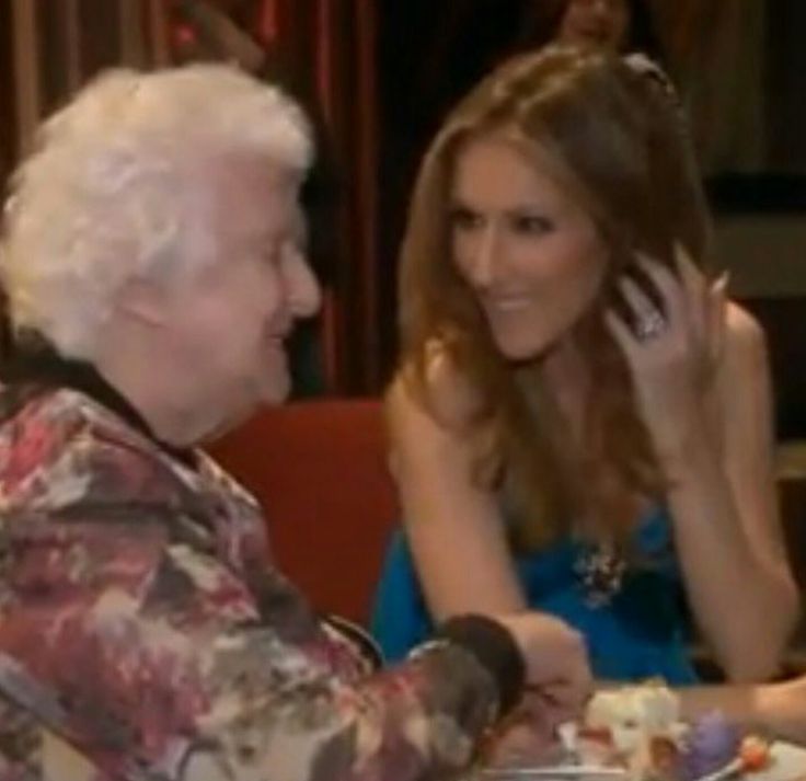 the woman is talking on her cell phone while sitting next to an elderly man in a chair