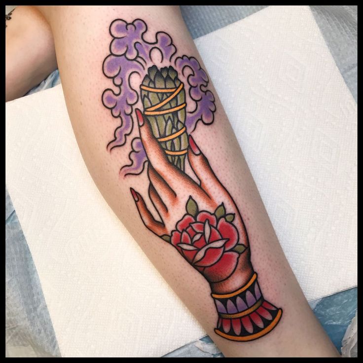 a woman's arm with a tattoo on it that has an image of a hand holding