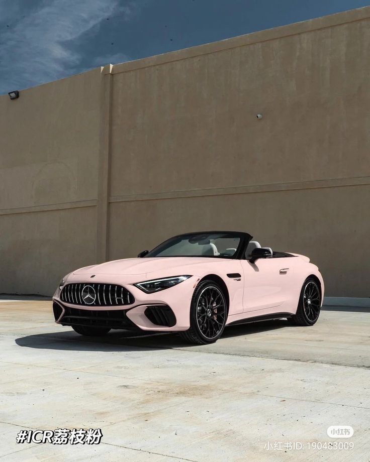 a pink sports car parked in front of a building