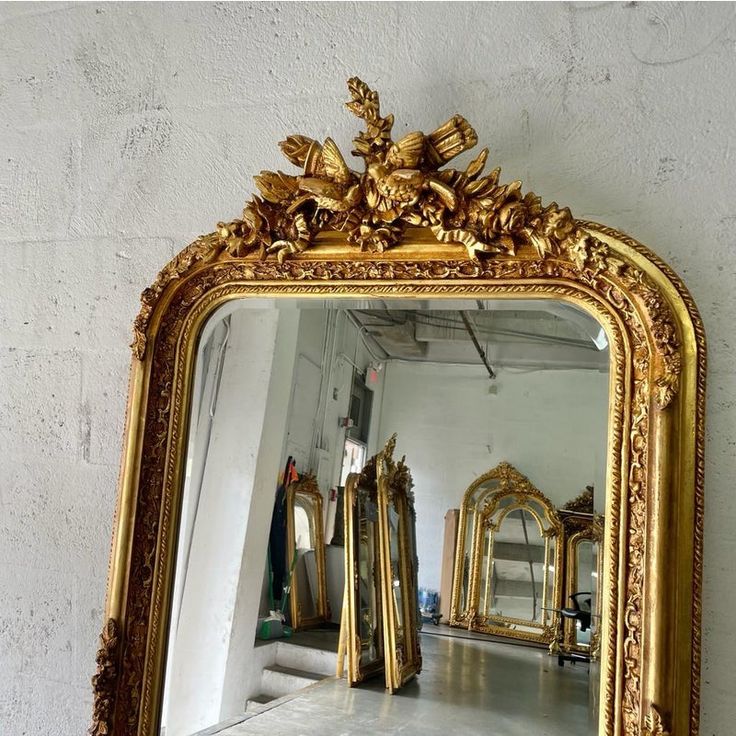 an ornate gold framed mirror on the wall