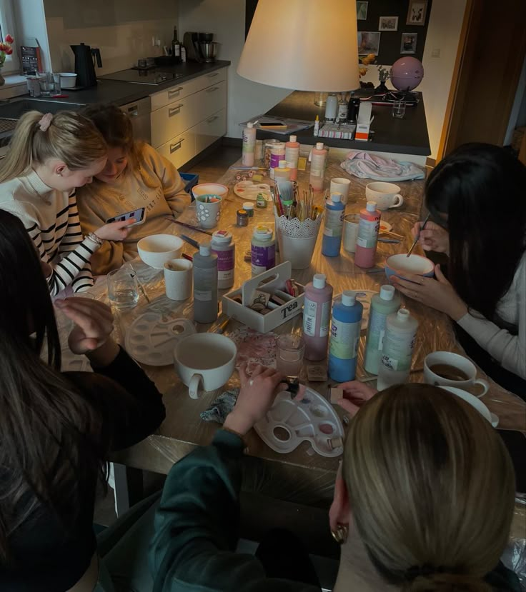 a group of women sitting around a table with cups and saucers on top of it