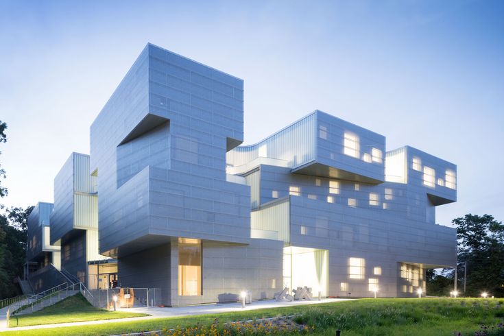 the building has many windows on it and is lit up in the evening sun at dusk