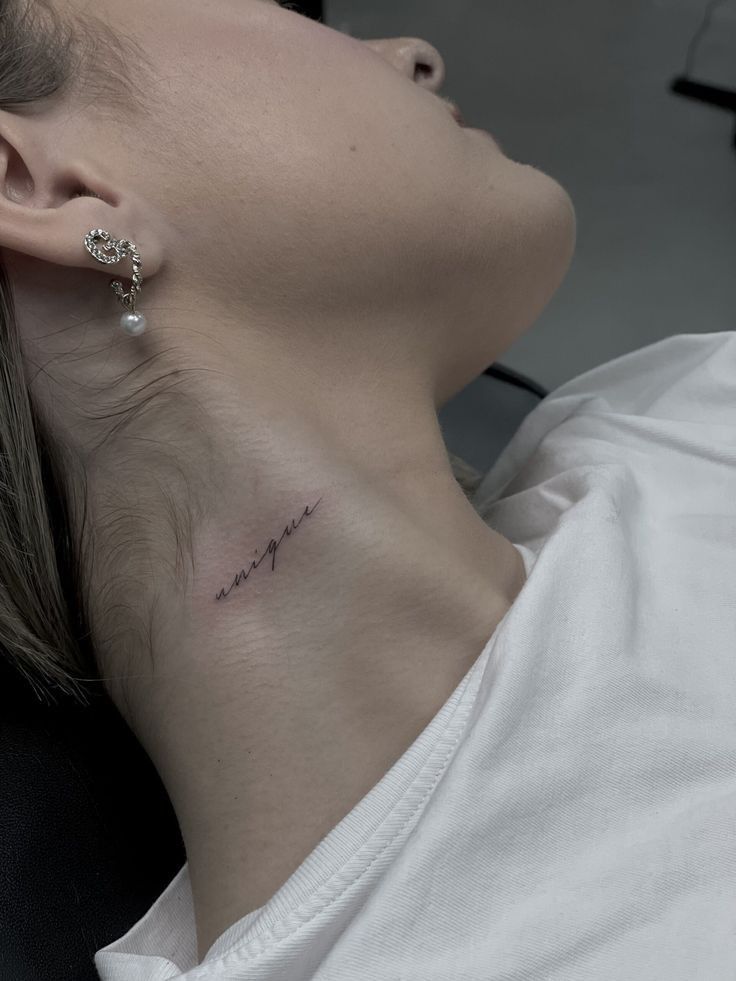 a woman with a small tattoo on her neck