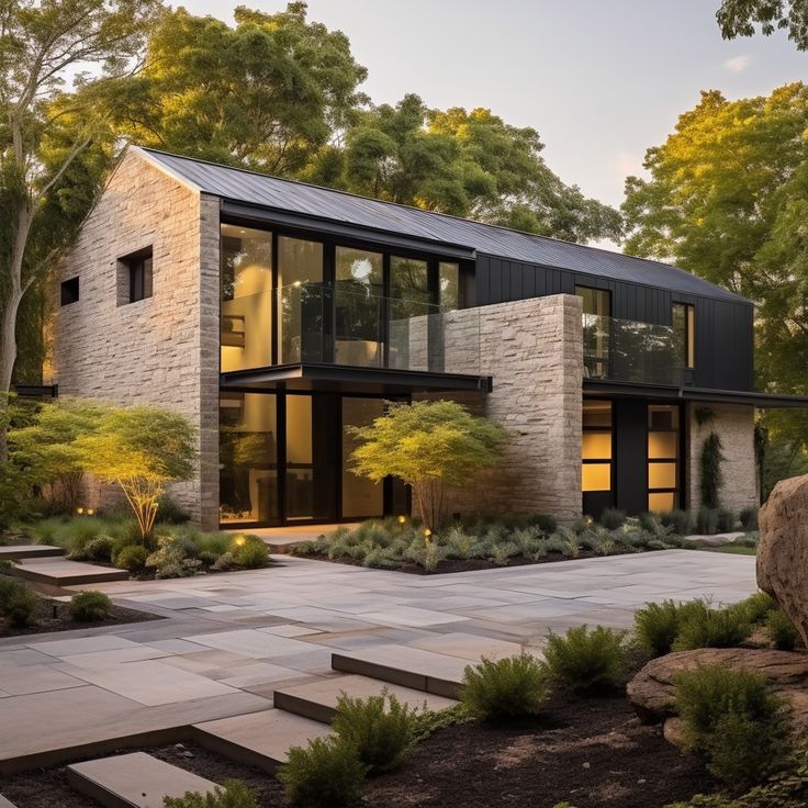 a modern house in the woods with stone steps leading up to it's entrance