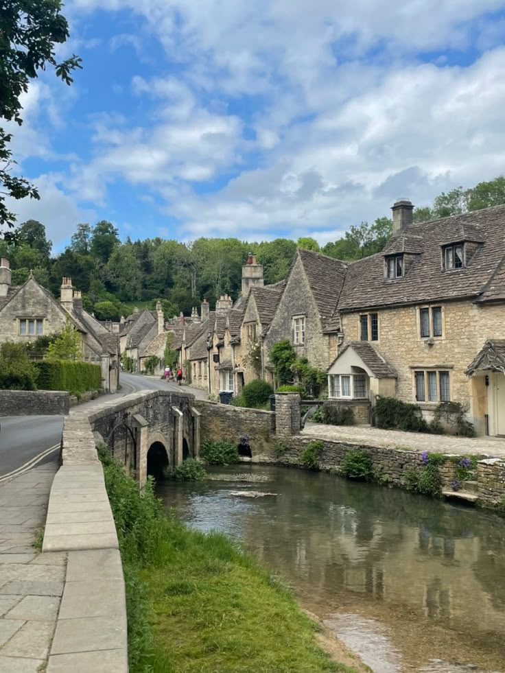 a river running through a small village next to tall buildings on the side of a road