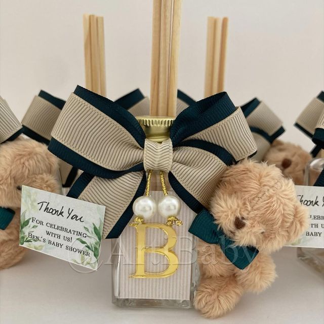 three teddy bears with tags attached to them sitting next to each other in front of candles