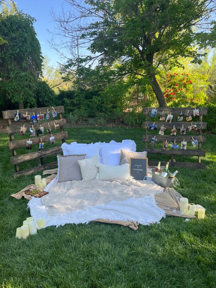 a blanket and pillows are laid out on the grass in front of some wooden pallets