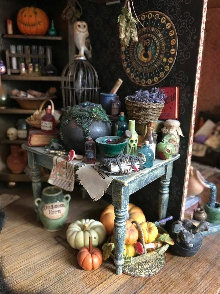 there is a small table with many items on it in front of a book shelf