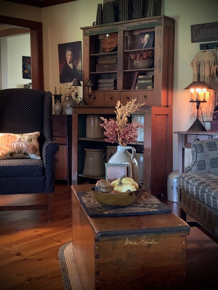 a living room filled with furniture and a wooden table topped with a vase full of flowers