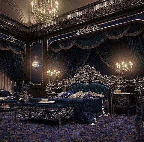 a fancy bedroom with blue and purple decor, chandelier and bed in the middle