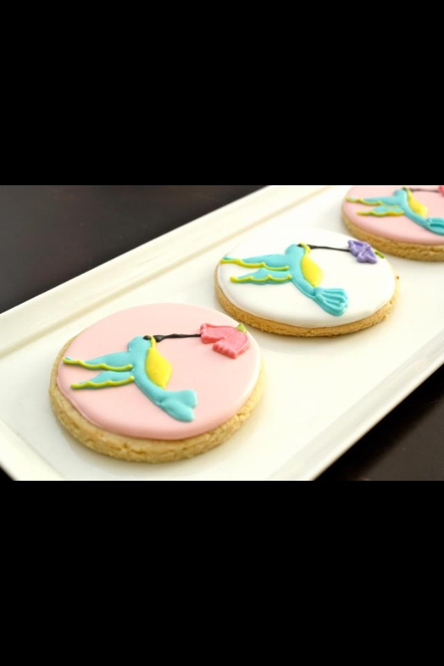 three decorated cookies sitting on top of a white tray