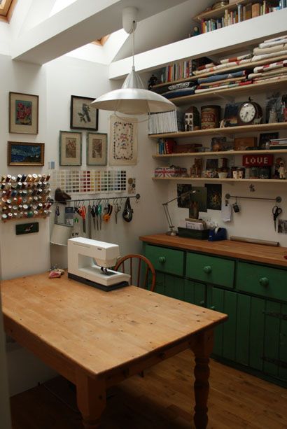 a table with a sewing machine sitting on top of it next to a shelf full of books