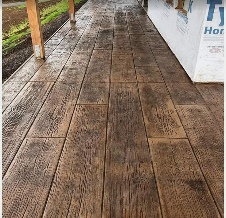 a porch with wood flooring next to a building