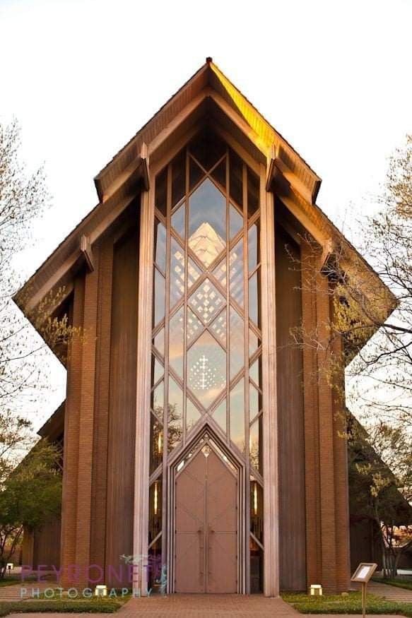 the front entrance to a church with large windows