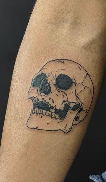 a black and white skull tattoo on the arm