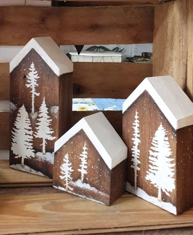 three small wooden houses with trees painted on them in the middle of a wood box