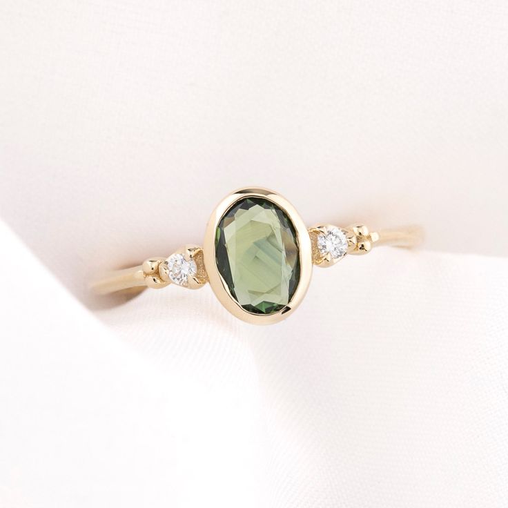 a close up of a ring with a green stone