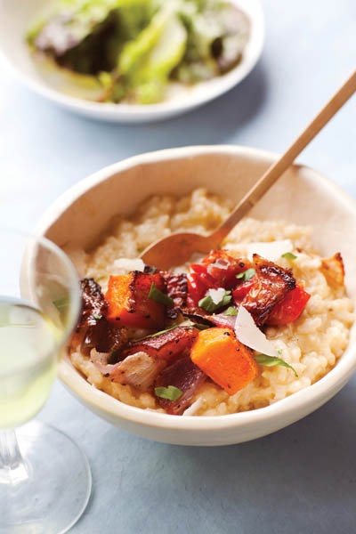 a bowl filled with rice and vegetables next to a glass of wine