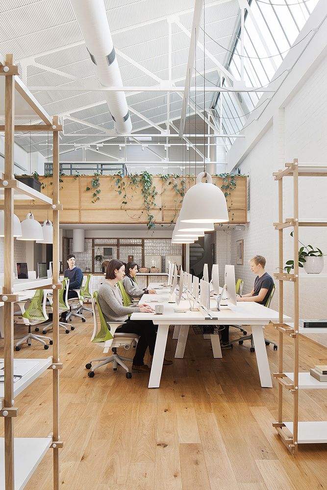 people are sitting at tables in an office