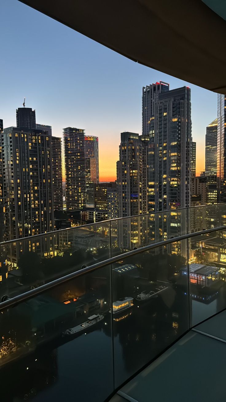 the city skyline is lit up at night, with skyscrapers in the foreground