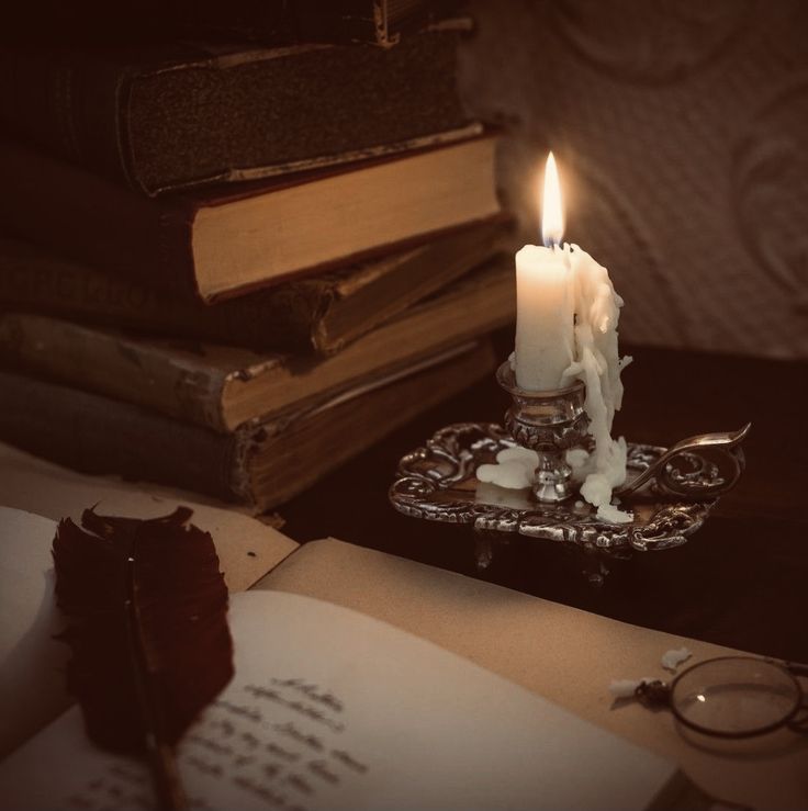 a lit candle sitting on top of an open book