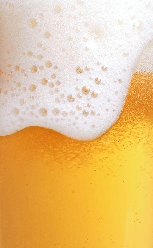 a close up view of a glass of beer with foamy frothy liquid