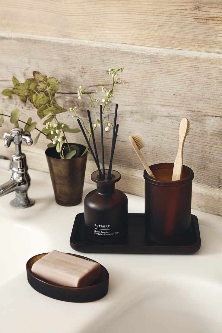 a bathroom sink with soap, toothbrushes and other items