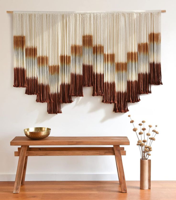 a wooden bench sitting in front of a window with curtains hanging from it's sides