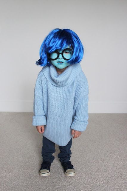 a young child with blue hair and glasses wearing a sweater, jeans and converse shoes