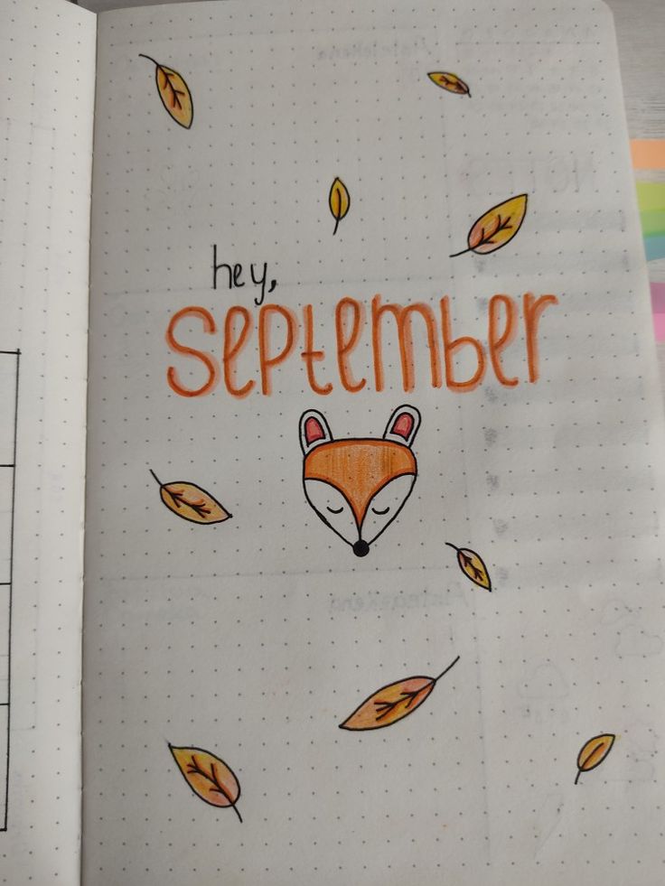 an open notebook with the words hey, september written in orange and black on it