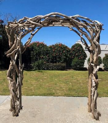 a wooden arch made out of branches in front of a house