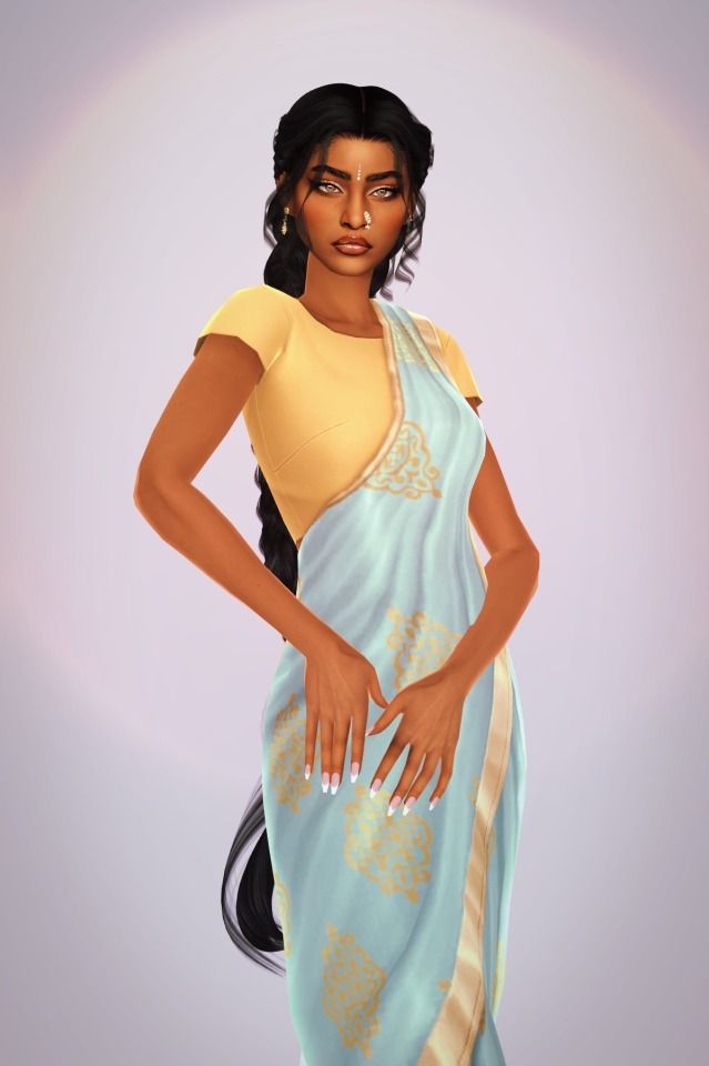 a woman in a blue and yellow sari with her hands on her hips, posing for the camera