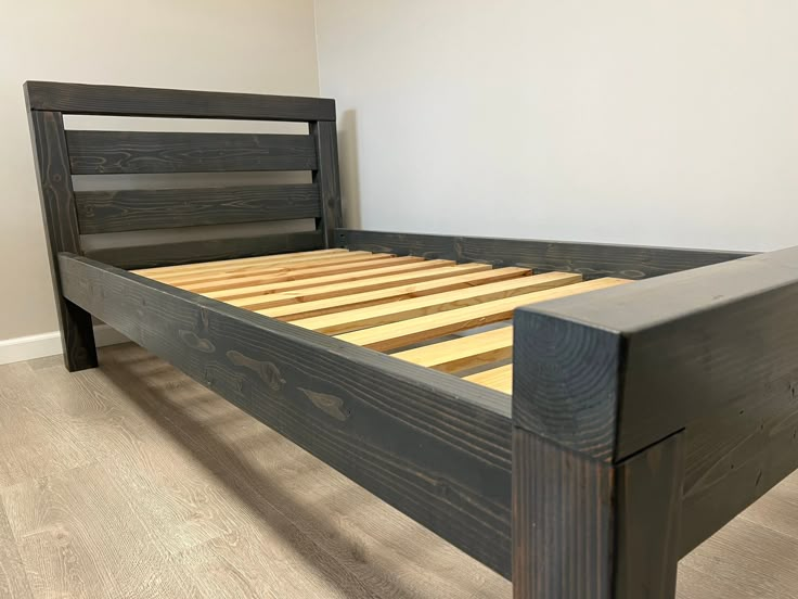 a bed frame made out of wood with no headboard and foot board on it