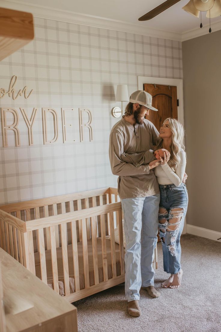 a man and woman standing in front of a baby crib