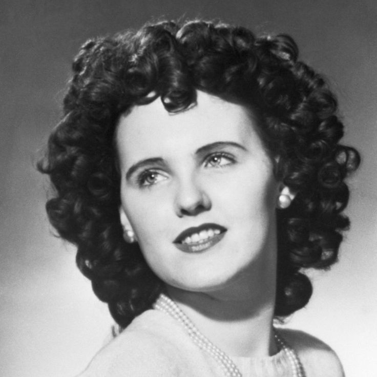 an old black and white photo of a woman with curly hair