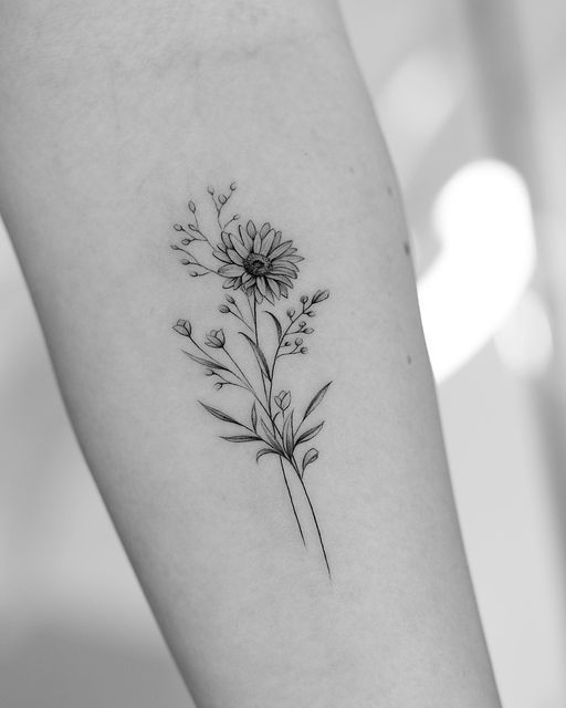 a black and white photo of a flower tattoo