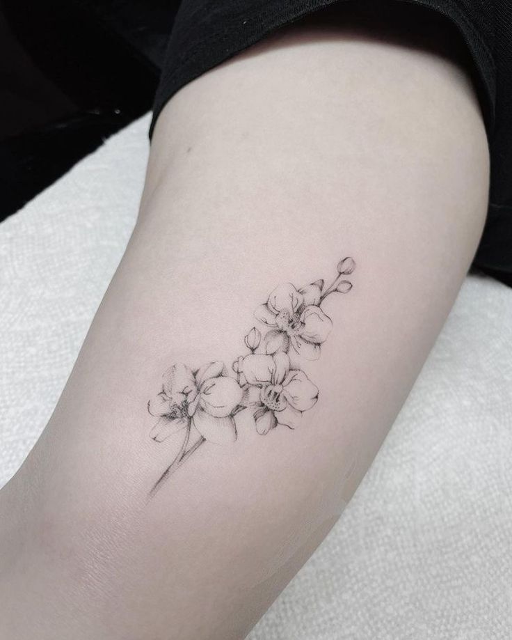 a small flower tattoo on the arm