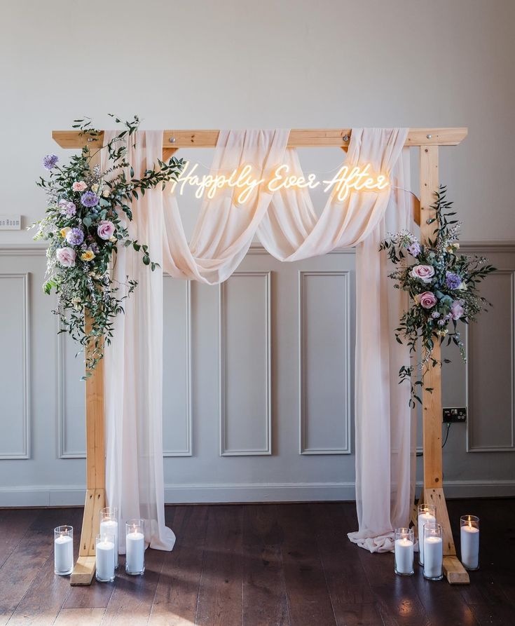 a wedding arch decorated with flowers and candles