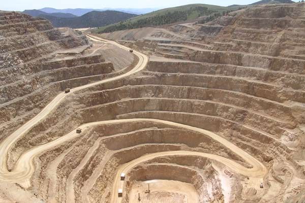 an aerial view of a dirt road in the middle of a large open pit area