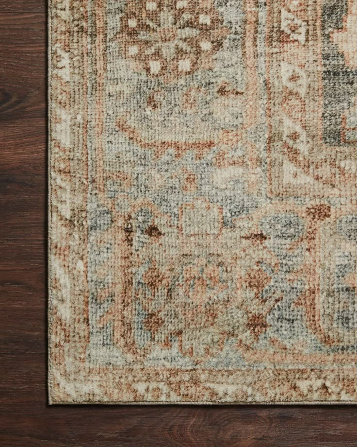 an area rug with brown, blue and beige colors on top of wooden flooring